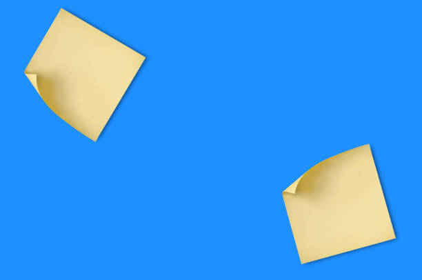 istock Two blank square yellow stickers with curved corner attached on blue table in office or fridge in home. Top view. Copy space for your text. Business or education concept 1098334014