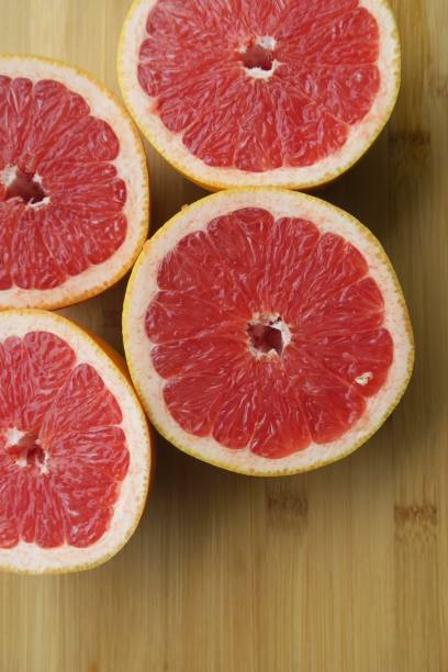 istock Image of sliced pink grapefruit on kitchen wooden chopping board, breakfast fruit 1098334534