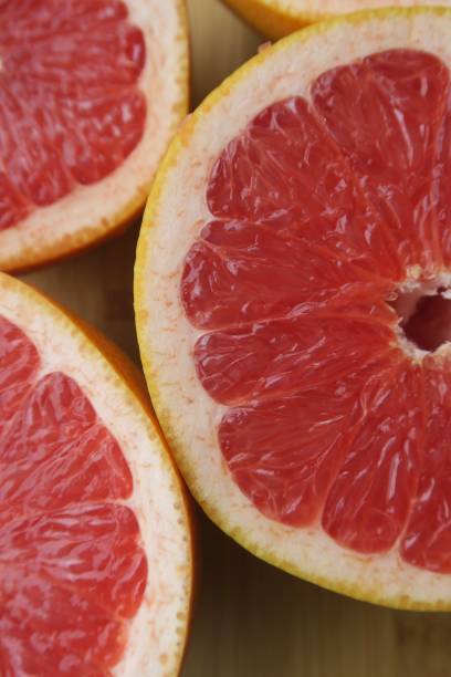 istock Image of sliced pink grapefruit on kitchen wooden chopping board, breakfast fruit 1098334572