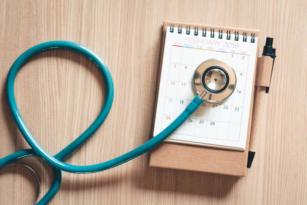 top view of stethoscope on calendar for health checkup concept., annual doctor appointment for physical check-up against wooden background., healthcare medicine and insurance concept. - physical checkup imagens e fotografias de stock