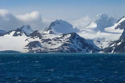 The landscape of the coast of Antarctica, Mountains covered with snow and ice-cold ocean.
