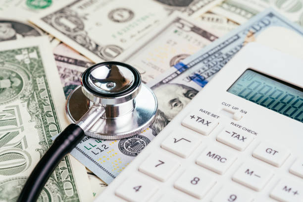 concept frais santé financière chèque, impôt ou médical et des soins de santé, stéthoscope mis sur l’emblème de la réserve fédérale fed sur les billets en dollars américains avec ratio blanc de calculatrice, la dette et revenus - currency stethoscope medicare usa photos et images de collection