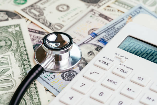 financial health check, tax or medical and health care expense concept, stethoscope put on fed federal reserve emblem on us dollar banknotes with white calculator, debt and revenue ratio - currency stethoscope medicare usa imagens e fotografias de stock