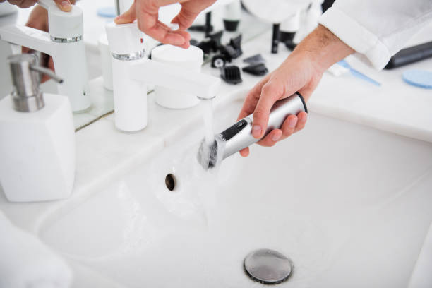 istock Hands opening the tap and washing the shaving machine 1098345784