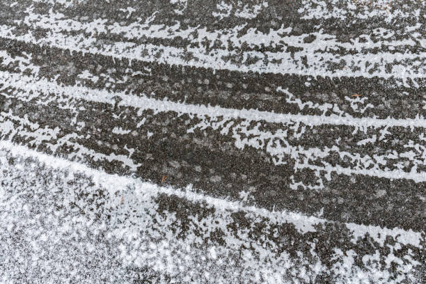 istock Ice and snow covered road surface on a cold winters day. Dangerous road conditions. 1098345888