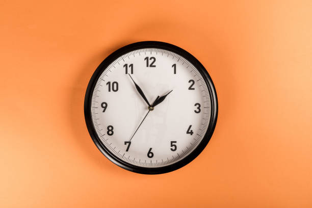 istock top view of round clock isolated on orange 1098347792