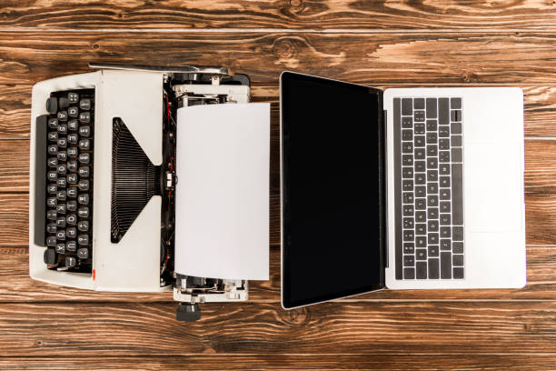 istock top view of typewriter and laptop with blank screen on wooden table 1098347854
