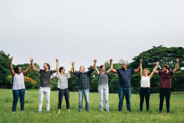 istock Happy diverse people holding hands in the park 1098348240