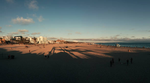 menschen am strand von santa monica bei sonnenuntergang - venice california santa monica pier sunset beach stock-fotos und bilder