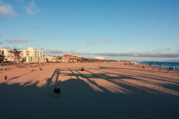 menschen am strand von santa monica bei sonnenuntergang - venice california santa monica pier sunset beach stock-fotos und bilder