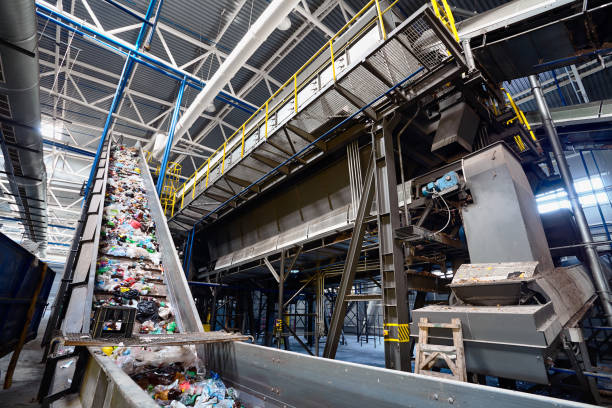 istock Wide angle view at recycling plant conveyor belt transports garbage inside drum filter or rotating cylindrical sieve with trommel 1098349532
