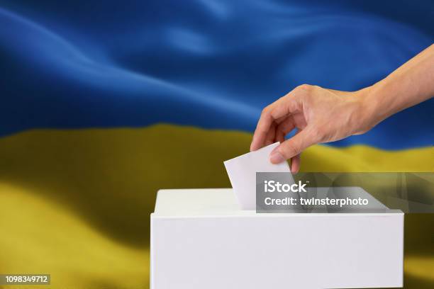 Primo Piano Delluomo Che Lancia E Inserisce Un Voto E Sceglie E Prendere Una Decisione Ciò Che Vuole Nel Casella Elettorale Con La Bandiera Ucraina Mescolata In Background - Fotografie stock e altre immagini di Ucraina