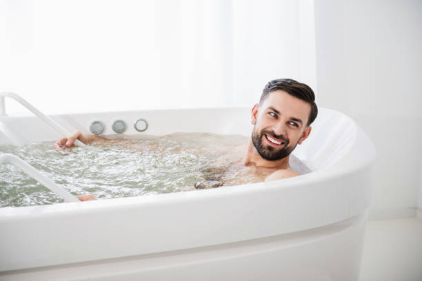 istock Emotional man smiling while being in hydro massage bathtub 1098349802