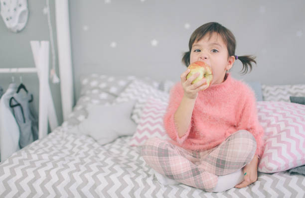 petite fille mange une pomme - eating obsessive child toddler photos et images de collection