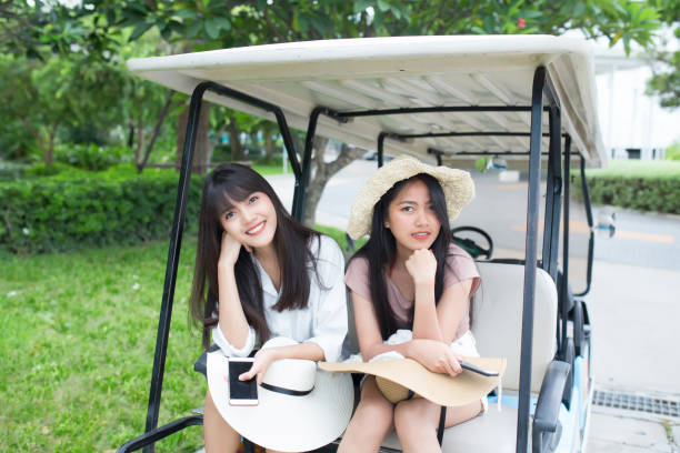 istock two young asian women sitting on golf cart 1098353050