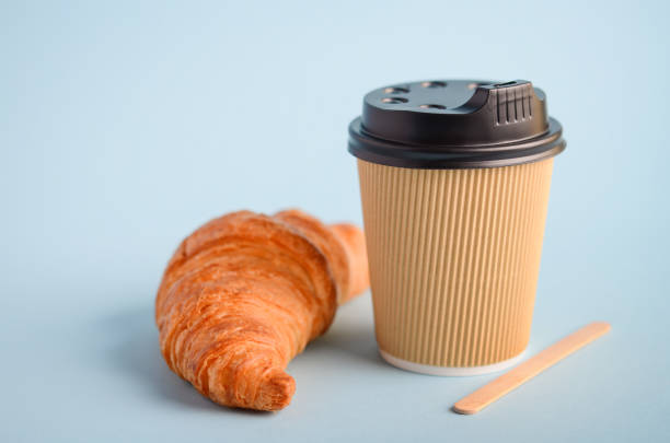 istock Take away coffee cup and croissant on blue background. 1098353206