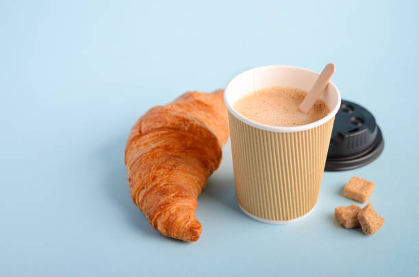 istock Take away coffee cup and croissant on blue background. 1098353236