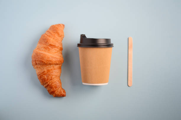 istock Take away coffee cup and croissant on blue background. 1098353242
