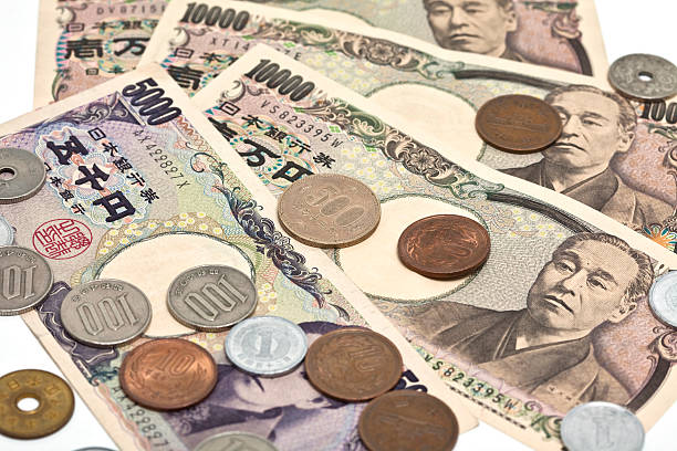 close up image of japanese yen on a white background - japanse valuta stockfoto's en -beelden