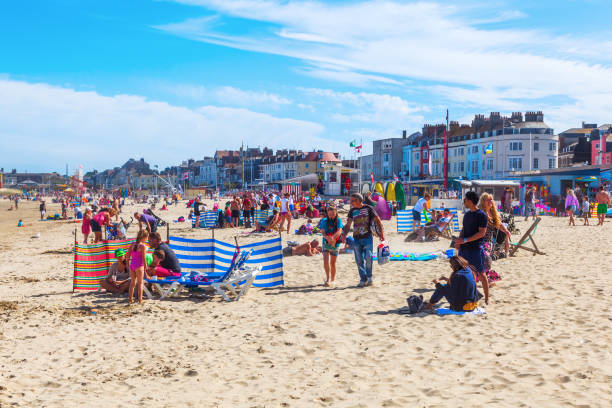 city beach of Weymouth, UK Weymouth, UK - July 05, 2015: city beach of Weymouth with unidentified people. It is a seaside town in Dorset and tourist resort, and its economy depends on its harbour and visitor attractions weymouth dorset stock pictures, royalty-free photos & images