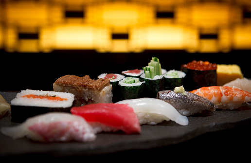 The range of different types of Sushi, Rolls and Maki with sauces and chopsticks. On rustic background