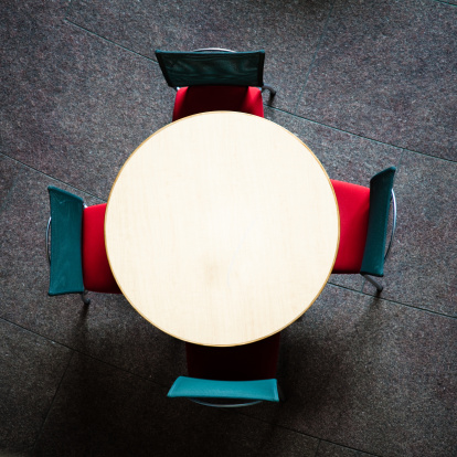 Abstract: Round table with four chairs from above.