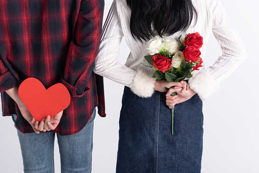 Beautiful Young couple at home,enjoy spend time together in celebration Saint Valentine's day,hand hold gift paper heart,red rose bouquet,happy and love motion.