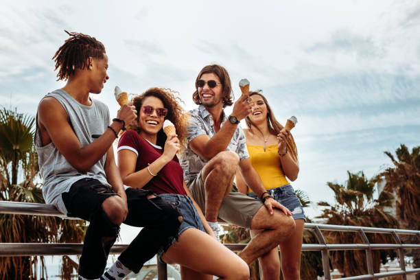 Cheerful buddies eating ice-cream outdoors