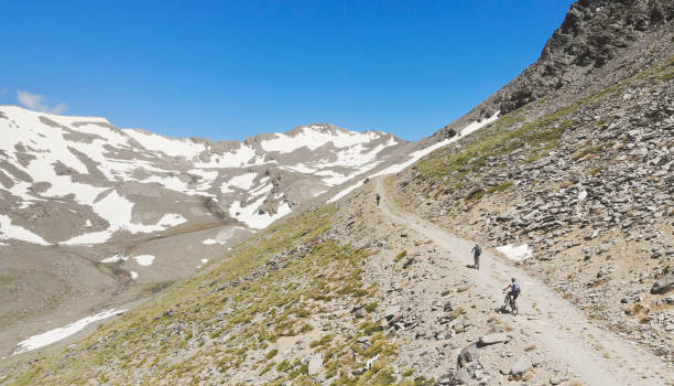 mountainbikers アンダルシア シエラ ・ ネバダ、スペインで高いの空撮。 - extreme terrain eroded snow landscape ストックフォトと画像