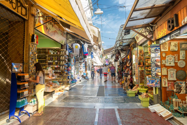 Shopping At Outdoor Market, Athens, Greece Athens, Greece - September 8, 2016: People shopping and buying souvenirs from markets at Plaka region of Athens, Greece. plaka athens stock pictures, royalty-free photos & images