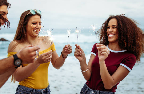 istock Multi-ethnic group of people with sparklers at the beach 1098381598