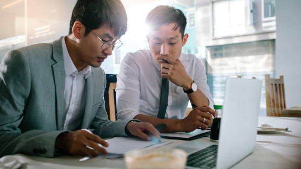 istock Two business people analysing some paperwork at cafe 1098385214