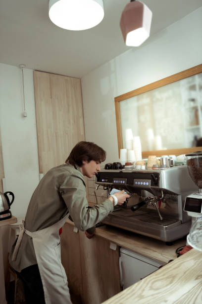 istock Tidy good-looking barista being concentrated on cleaning surfaces 1098387628