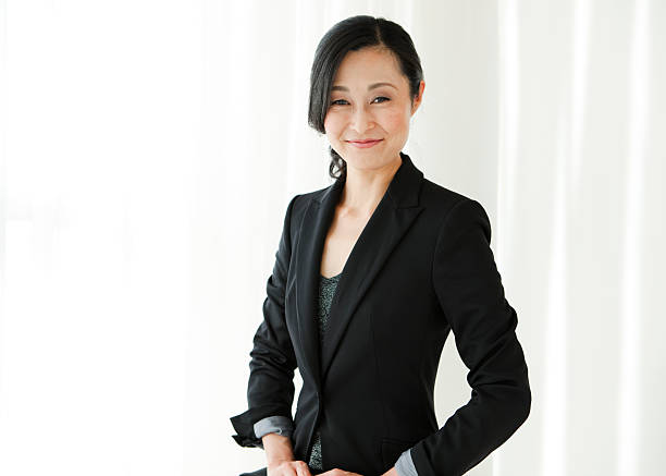 Smiling Asian businesswoman in black suit stock photo