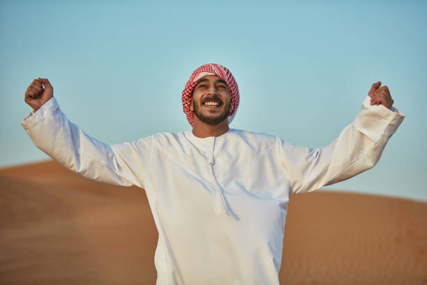 istock Happy Arab man with arms raised in desert 1098399908
