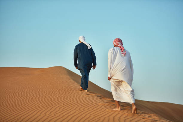 istock Arab men walking on sand at desert 1098400186
