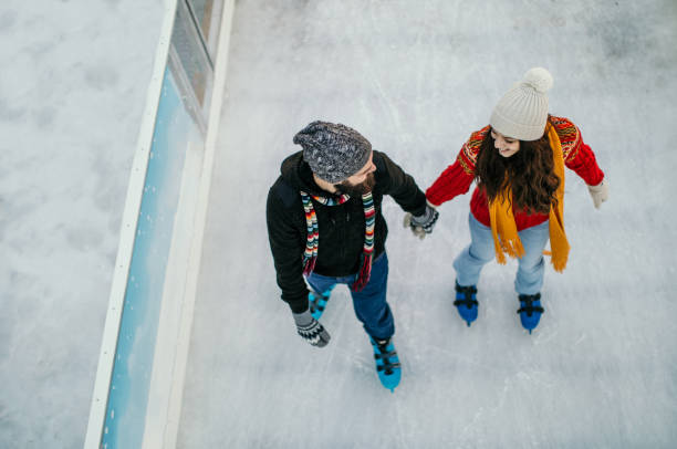 We love to skate Couple skating during winter season ice skating photos stock pictures, royalty-free photos & images
