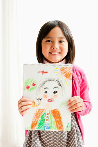 Little girl showing drawing of her father.