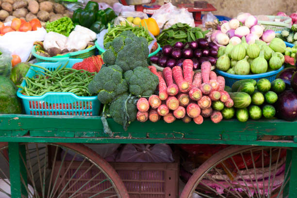 Image of ripe vegetable produce, aubergines, carrots and peppers on market stall trolley in India Fresh vegetable produce, including aubergines, carrots and peppers, displayed at market stall in India. ceiba tree photos stock pictures, royalty-free photos & images