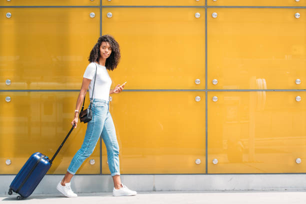 wanita di ponsel sambil berjalan dengan koper - london fashion potret stok, foto, & gambar bebas royalti