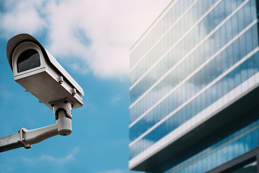 Security camera with a glass building on the background on the street