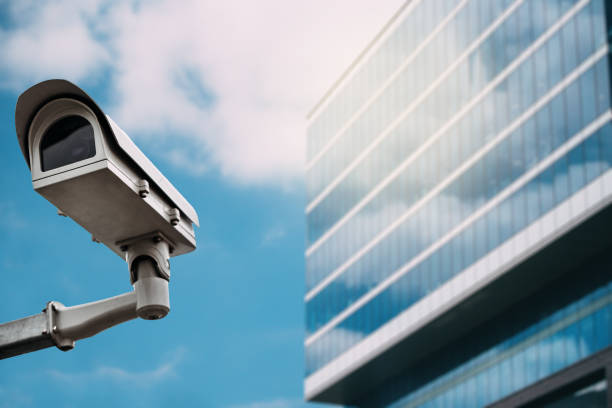 камера видеонаблюдения со стеклянным зданием на заднем плане - financial district audio стоковые фото и изображения