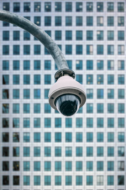 Security camera with a glass building on the background on the street