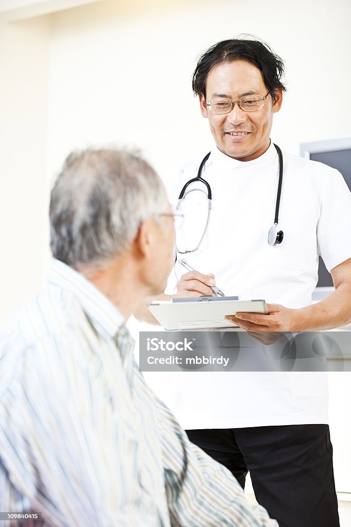 Japonés médico y paciente hablando en la sala de espera - Foto de stock de Diálogo libre de derechos
