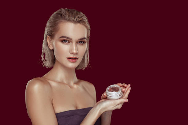 istock Model wearing open shoulder top holding face cream 1098407714