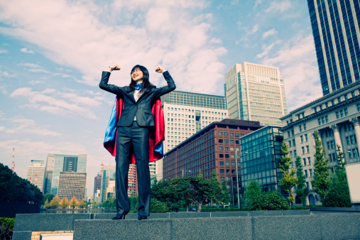 A young Japanese businesswoman flexes her muscles to Tokyo.
