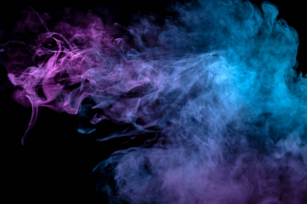 istock Multicolor, thick smoke, illuminated by colored in blue, purple and pink light against a dark black isolated background, welded with clubs and curls, rising from a steam of vape. Wind blow 1098413632
