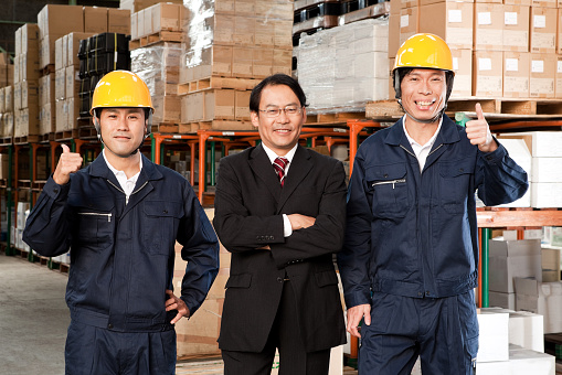 japan businessman is posing with warehouse's worker