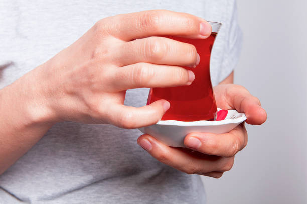 One cup of tea woman's in hand on white background. Ready to drink.