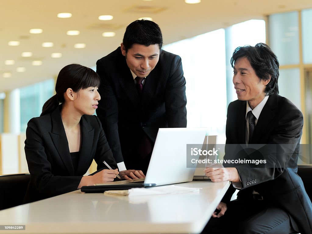 Los empresarios trabajando juntos en la computadora portátil - Foto de stock de 20 a 29 años libre de derechos